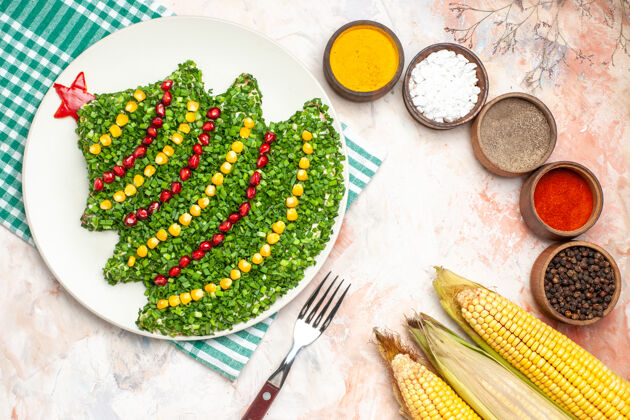 健康顶视图美味的绿色沙拉在新年树形状与调味品上的灯光背景背景树晚餐