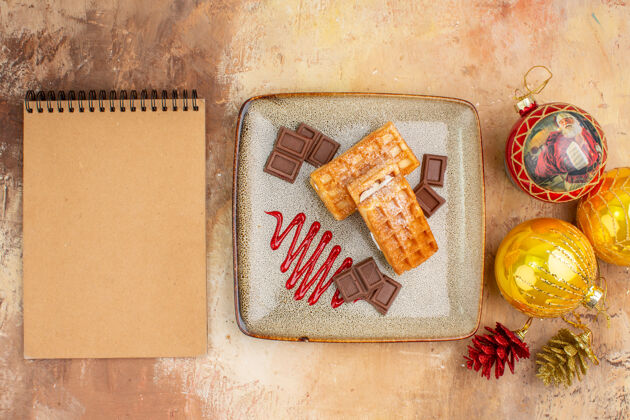 巧克力顶视图美味的华夫饼与巧克力和新年树玩具在灯光背景奶油年新的