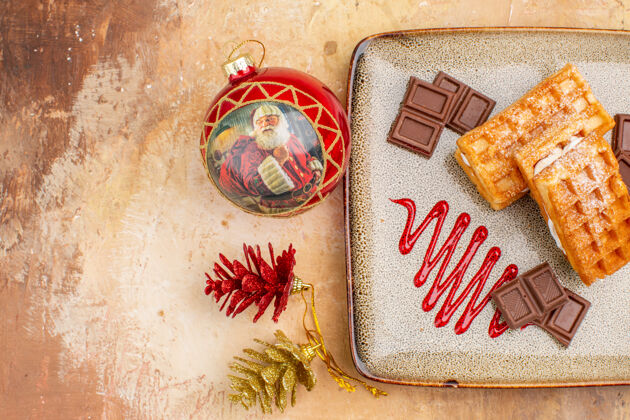 背景俯瞰美味的华夫饼与巧克力条棕色背景旧的圣诞节粗麻布