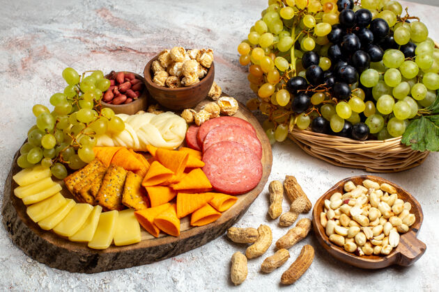 水果前视图不同的零食新鲜葡萄奶酪cips与坚果在白色空间饮食健康葡萄