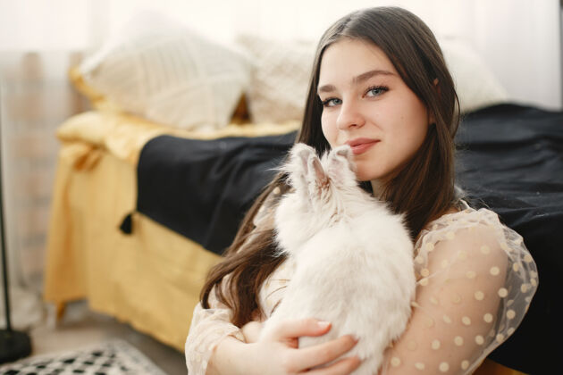 休息长发女孩抱着一只白兔休闲舒适室内