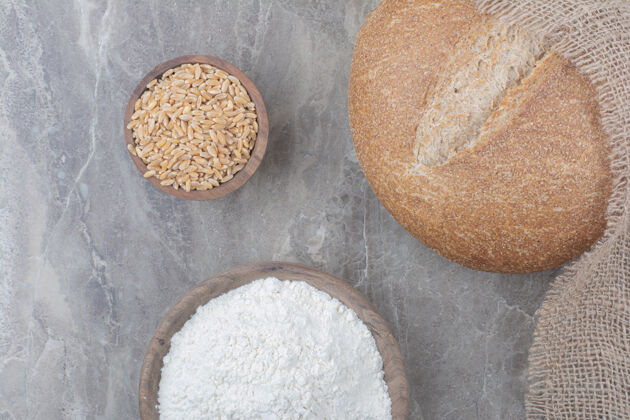 美味一条白面包 在大理石表面涂上燕麦和面粉脆面粉谷物