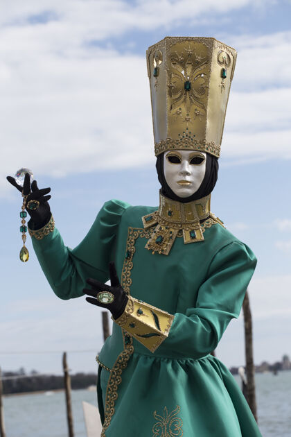 娱乐在举世闻名的嘉年华期间 身着传统威尼斯面具的女性人物节日女人