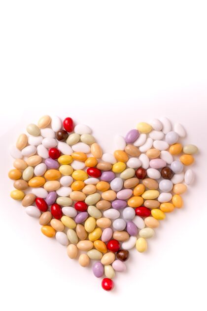 浪漫心形果冻豆的垂直拍摄 在白色背景上隔离棕色符号心脏