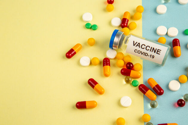 药品正面图黄蓝色背景上的不同药丸疫苗大流行医院冠状病毒-科学病毒实验室药品健康颜色病毒视图背景