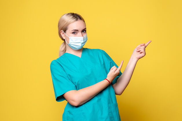 成人黄墙上年轻女医生穿着医用衬衫 戴着口罩的正面图人物医疗人物