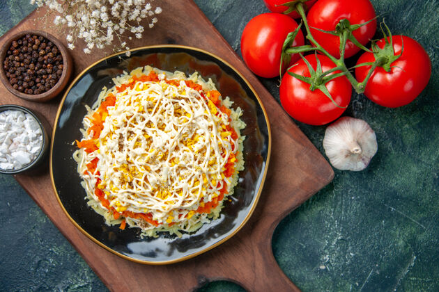 红色顶视图美味含羞草沙拉在盘子里与深蓝色背景上的红色西红柿番茄晚餐盘子