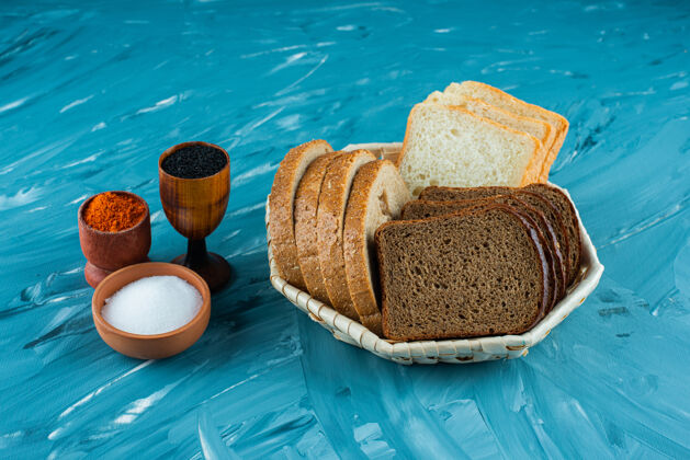 糕点各种新鲜面包放在一个篮子里 在浅色的背景上放上盐和胡椒皮塔新鲜箱子