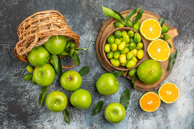 多汁从远处俯瞰苹果绿色的苹果 篮子里有叶子 木板上有柑橘类水果新鲜酸橙柑橘