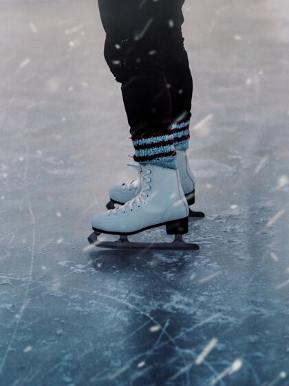 比赛垂直特写一个人在雪地上的白色溜冰鞋在降雪降雪运动冷