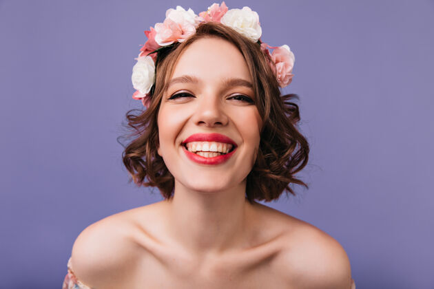 积极特写镜头：头发上开着粉色花朵的快乐白人女孩情绪激动的高加索女士微笑着爱花花