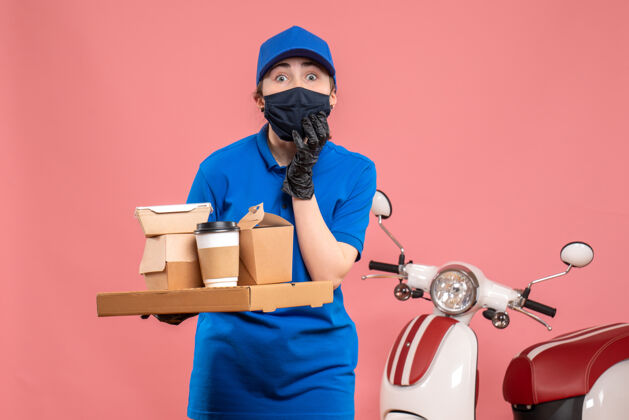 送货正面图：女快递员在粉色大流行工作服上送咖啡和食物-制服工作服男人工作人