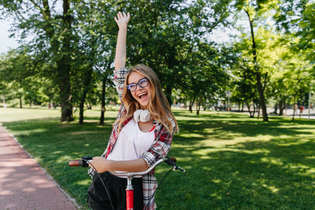 活动优雅的金发女孩表达兴奋户外照片快乐的白人女士与自行车在公园摆姿势可爱田野快乐