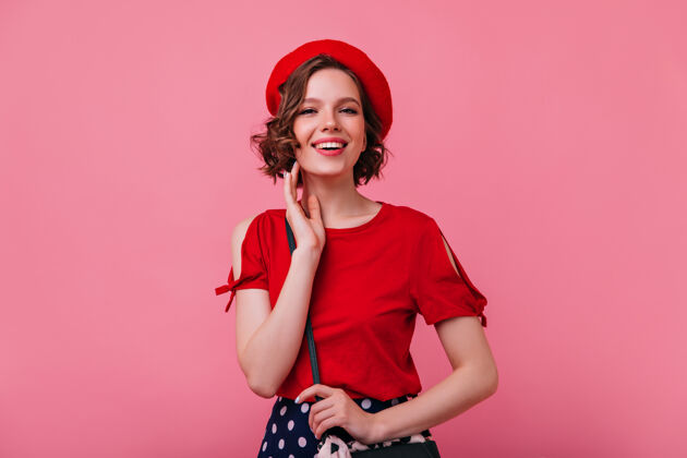 休息快乐的法国女孩摆出快乐的表情优雅时尚的女士戴贝雷帽微笑的肖像模特粉色女人