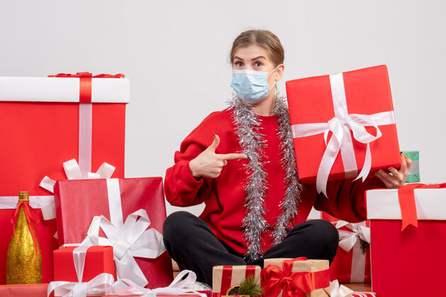 病毒正面图年轻女性围坐在圣诞礼物旁礼物年轻的女性圣诞节