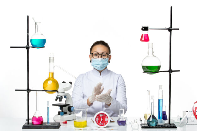 科学前视图穿着白色医疗服的女化学家 戴着白色背景上的口罩拍打着化学家病毒-飞溅实验室医生前面鼓掌
