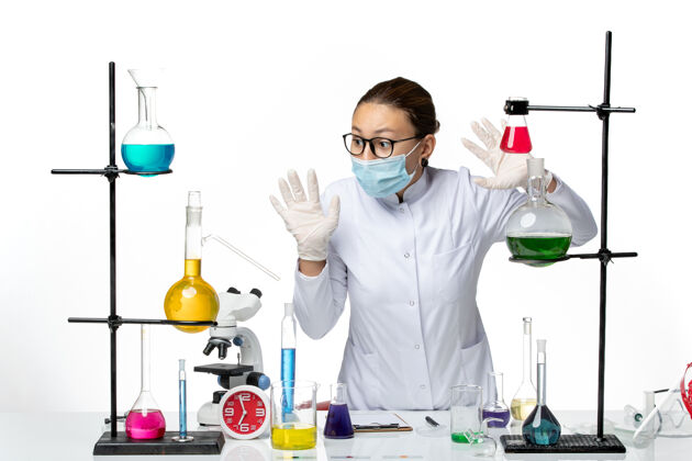 实验室前视图穿着医疗服的女化学家戴着面罩在白色地板上工作病毒化学实验室covidsplash医学工作西装