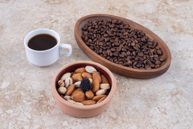 咖啡一碗什锦坚果 一盘咖啡豆和一杯黑咖啡豆类美味