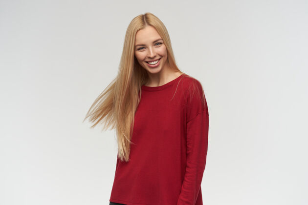 女性有吸引力的 金发长发的成年女孩的肖像穿着红色毛衣人和情感的概念看着镜头 在白色背景下孤立年轻成人毛衣