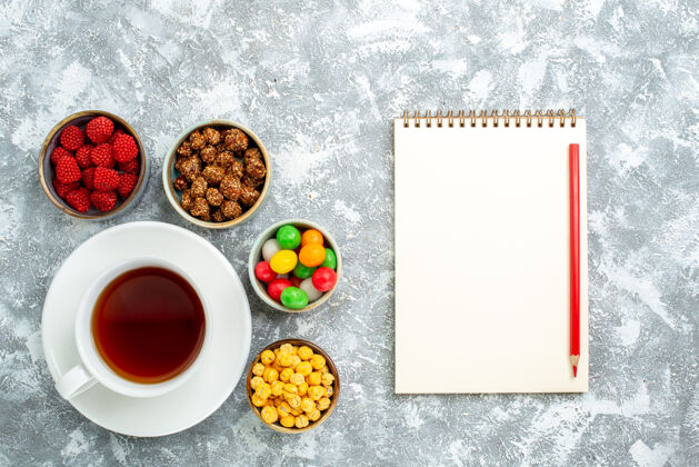 膳食俯视不同的糖果与坚果和一杯茶在白色空间糖果谷类食品早餐