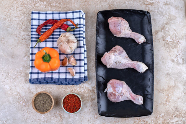 好吃生鸡腿肉和蔬菜放在深色的木板上生的板西红柿