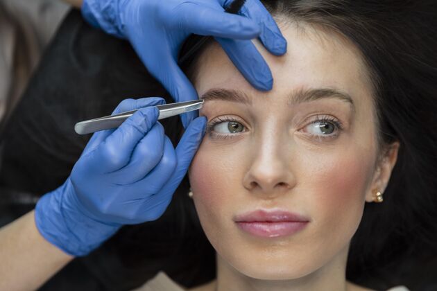 美容院美容师正在为她的女客户做眉毛护理美容女人专业