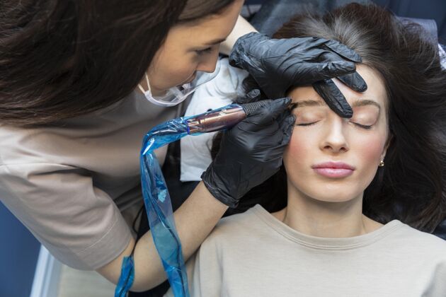 专业美容师正在为她的客户做眉毛护理治疗女人美容