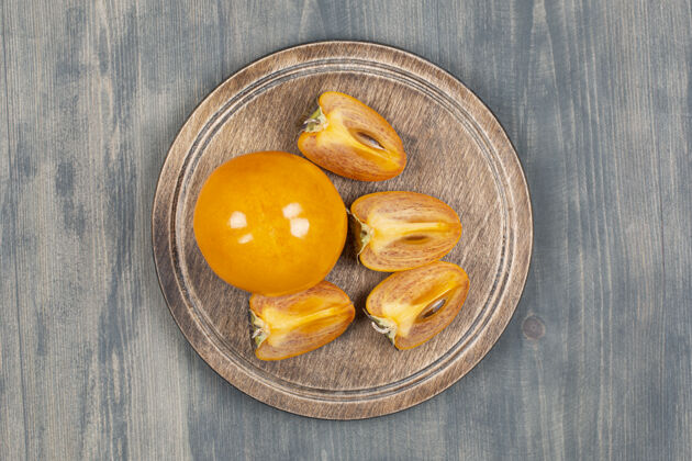 甜点把美味的柿子片放在木盘里柿子美食木材