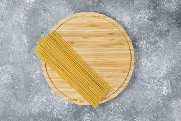 意大利面把生的干意大利面木板放在大理石表面上烹饪长的营养