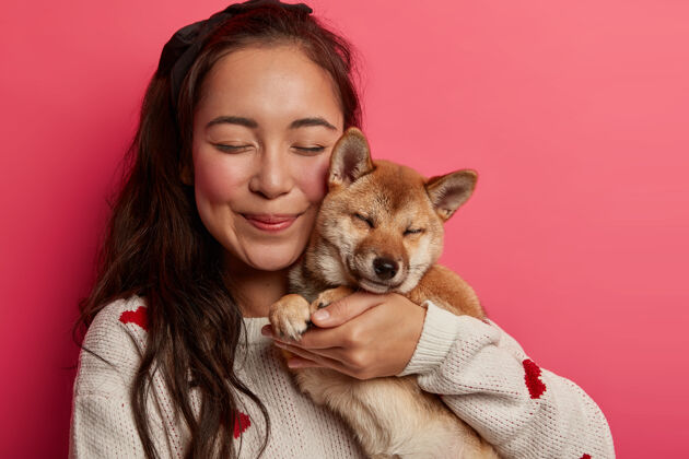 朋友快活亚洲女人特写镜头把纯种狗抱近脸 从喜悦闭上眼睛 用爱拥抱动物收养自由空间感情