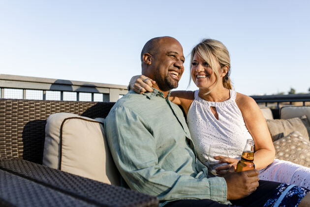 酒杯丈夫和妻子在他们的屋顶上放松在covid-19封锁庆祝浪漫女人