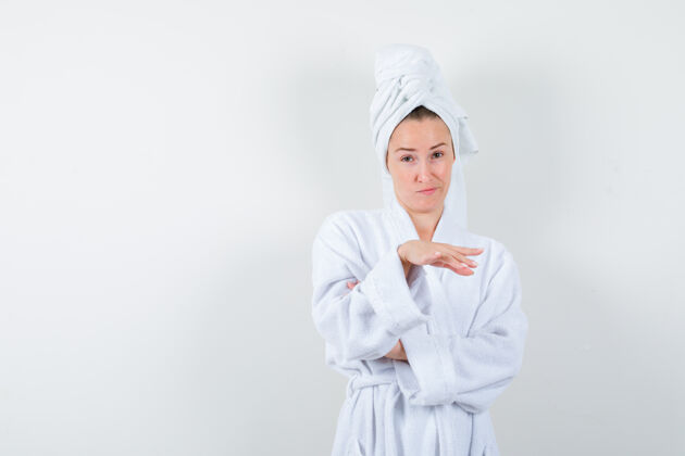 女孩身穿白色浴袍的年轻女子 用手帕遮住东西摆姿势 表情可疑 正视图人人女性
