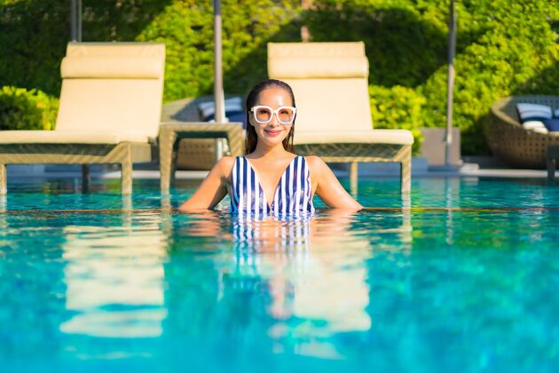 海滩肖像美丽的年轻女子放松微笑休闲度假酒店游泳池周围女性成人比基尼