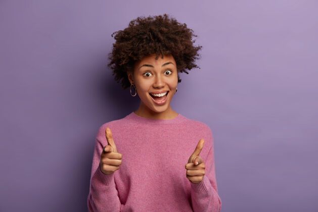 搞笑快乐的美国黑人女人卷发指着对着镜头 假装拍摄 选择或挑选你 砰砰满意指数手指