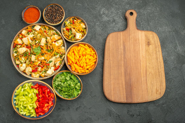 勺子顶视图鸡肉沙拉搭配蔬菜上深色餐桌饮食沙拉健康蔬菜盘子鸡肉沙拉