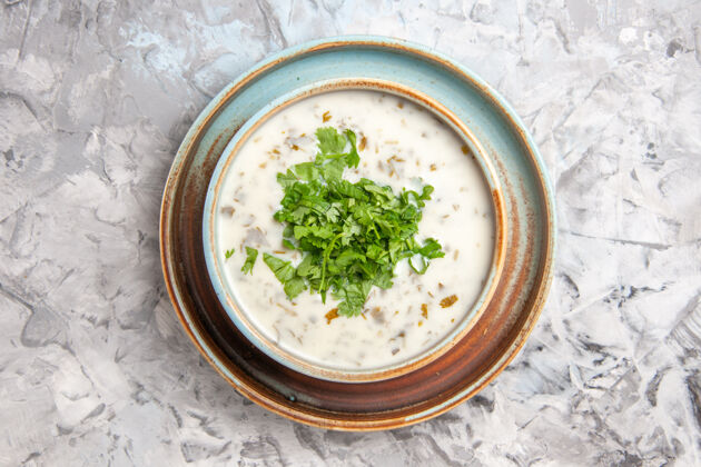 盘子俯瞰美味的dovga酸奶汤与绿色内盘上的白色餐桌牛奶汤一餐绿色食物汤