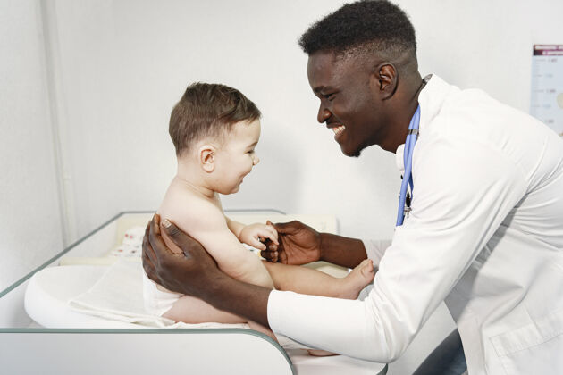 病人黑人医生穿尿布的婴儿带听诊器的非洲人男人专业人士检查