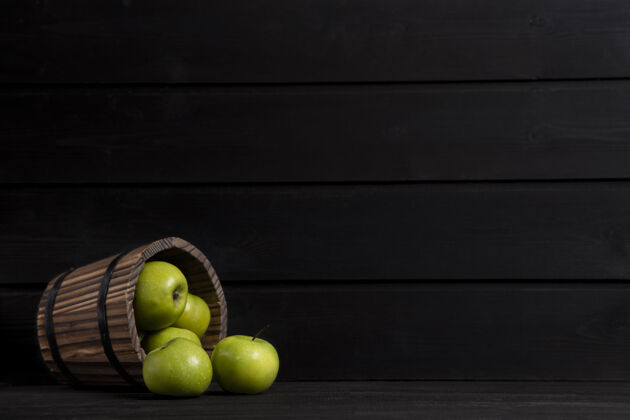 饱满一个装满成熟青苹果的木篮放在一张深色的木桌上高质量的照片营养纯净有机