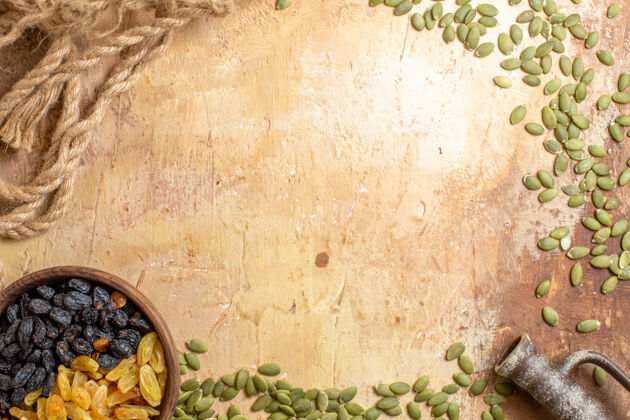 框架顶部特写查看葡萄干葡萄干在旁边的南瓜种子绳碗垃圾年份葡萄干