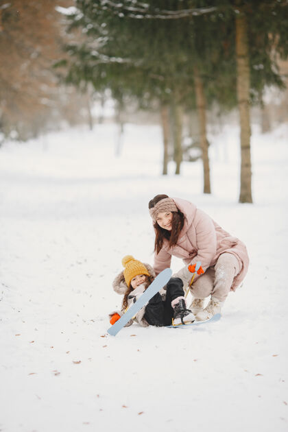 公园小女孩和妈妈一起越野滑雪健康家庭下雪