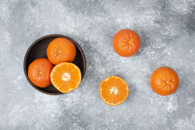 甜点石桌上摆满了橙子汁的木碗成熟热带柑橘