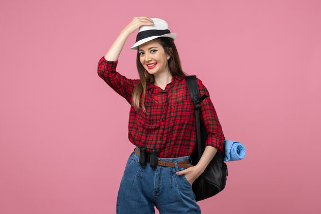 成人正面图：穿着红色衬衫 戴着粉色背景颜色帽子的年轻女性休闲人年轻女性