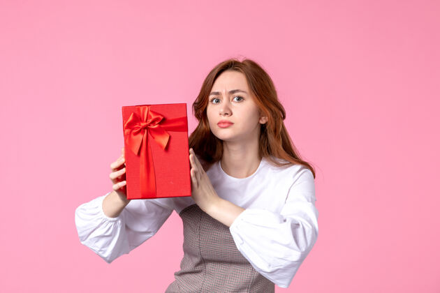礼品正面图：年轻女性 红色包装 粉色背景 相亲日期 三月横向性感礼物 香水 女士照片年轻女性礼品香水