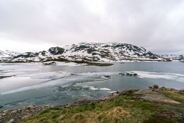 雪挪威的雪山和冰冷的河流美丽山天空
