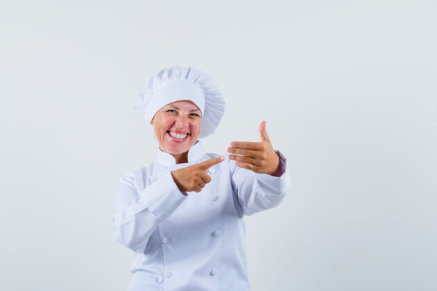 厨师一位身穿白色制服的女厨师指着名单 兴高采烈地看着魅力乐趣女性
