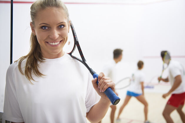 健身俱乐部活跃的年轻人打壁球姿势女人运动器材