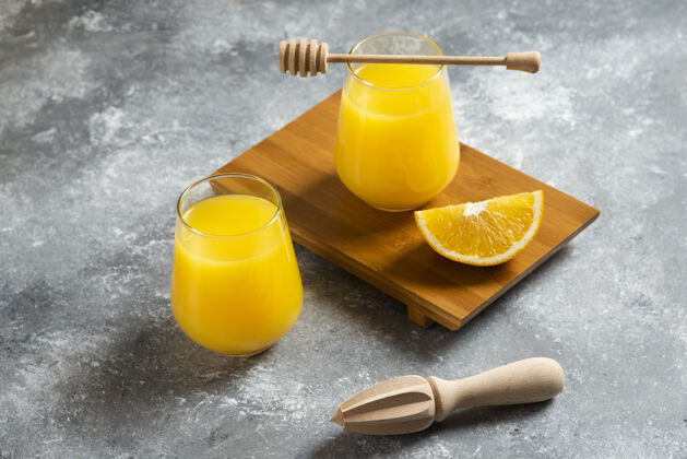 新鲜一杯橙汁和一把木铰刀成熟有机明亮