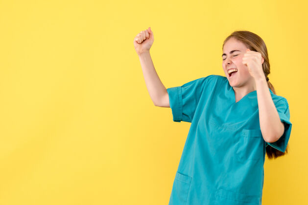 微笑正面图黄色背景上的女医生欢呼雀跃医疗卫生院病毒情感成功欢欣鼓舞男性