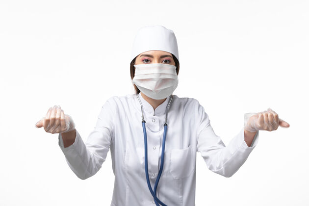 男人正面图女医生穿着白色医疗服 戴着口罩 因冠状病毒对淡白色壁病病毒大流行冠状病毒外套实验室外套