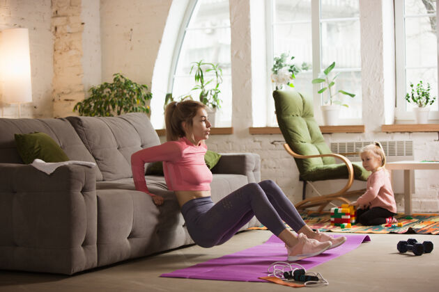 活动坐沙发锻炼年轻女子在家锻炼运动装运动瑜伽